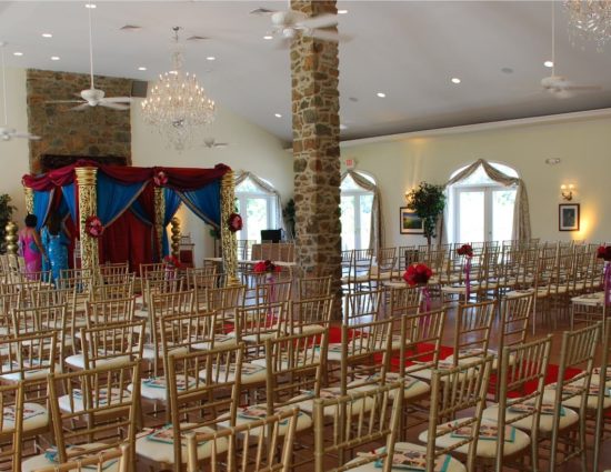 Large room with concrete flooring set up for wedding ceremony