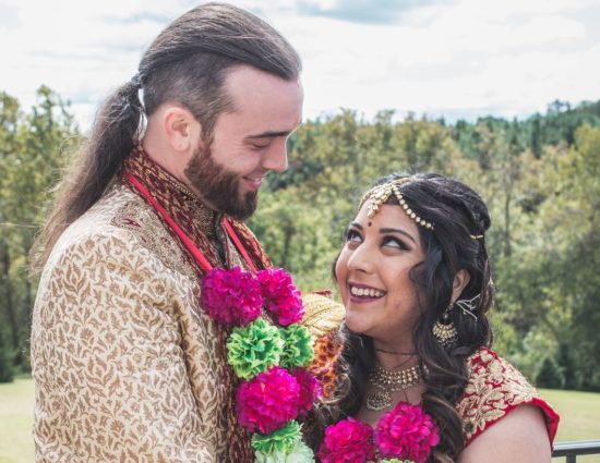 Bride and groom with traditional Indian wedding attire looking at each other