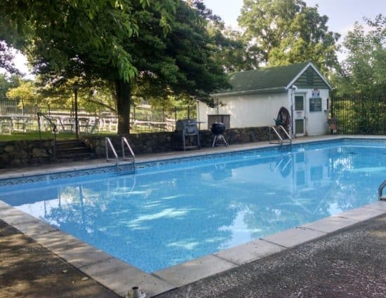 Tables set up for wedding reception near pool with clear water