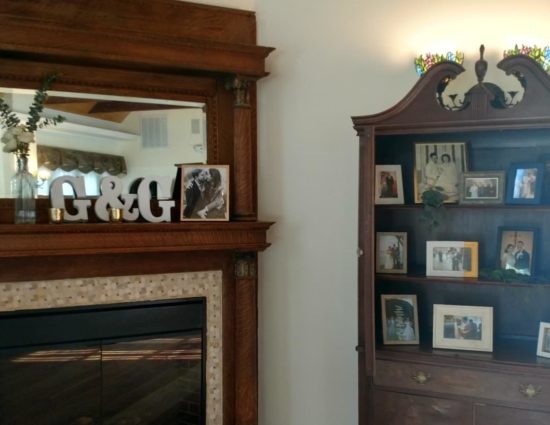 Dark wooden hutch next to a fireplace with large wooden mantel and mirror