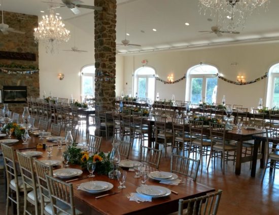 Large room set up with wooden tables and chairs for a large wedding reception