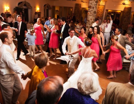 Group of people circled around the bride and groom with everyone dancing