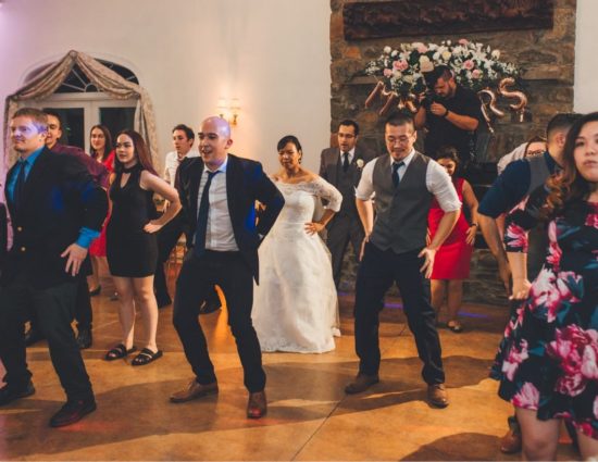 Group of wedding guests doing a line dance with the bride and groom