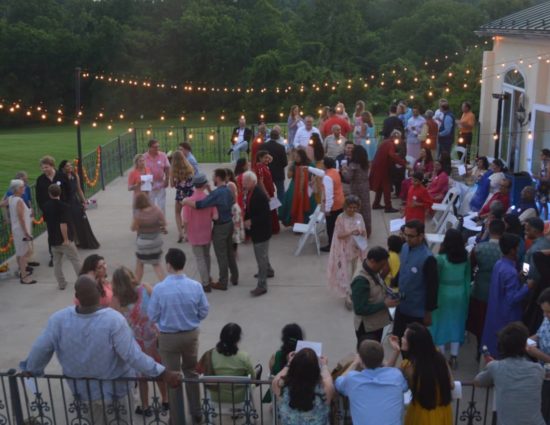 Large wedding party on concrete patio with people talking to each other