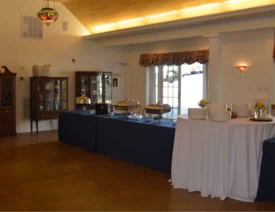 Large room with concrete flooring with buffet tables with navy and white tablecloths