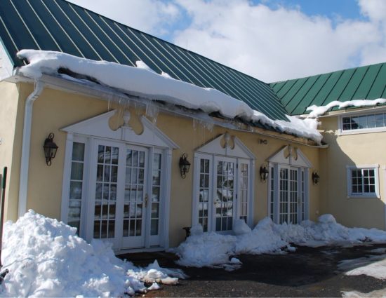 Events building painted cream with green roof covered in snow