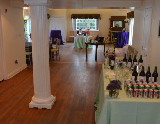 Large room with hardwood flooring set up for wedding reception