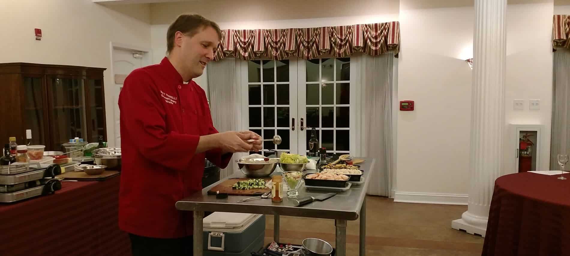 Chef in red shirt giving presentation on how to prepare a meal