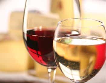 Close up view of two wine glasses, one with white wine and the other with red wine