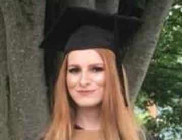 Woman with long red hair and black graduation cap