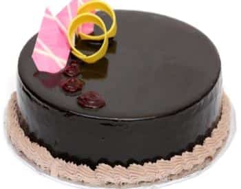 Dark chocolate cake with yellow and pink decorations on top