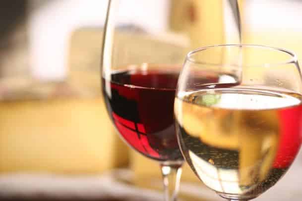 Close up view of two wine glasses, one with white wine and the other with red wine