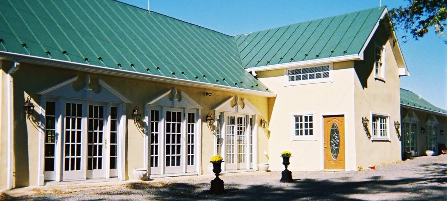 Exterior view of Fox Den events center painted cream with white trim and dark green roof