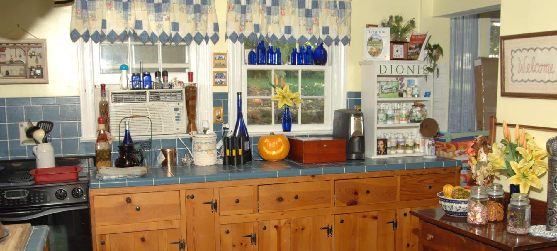 Kitchen with wooden cabinets, blue gray tile countertops and backsplash, and yellow walls