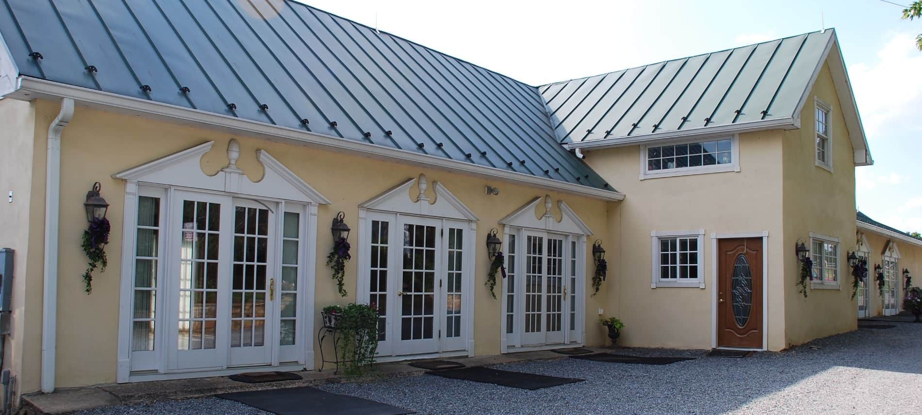 Exterior view of Fox Den events center painted cream with white trim and dark green roof