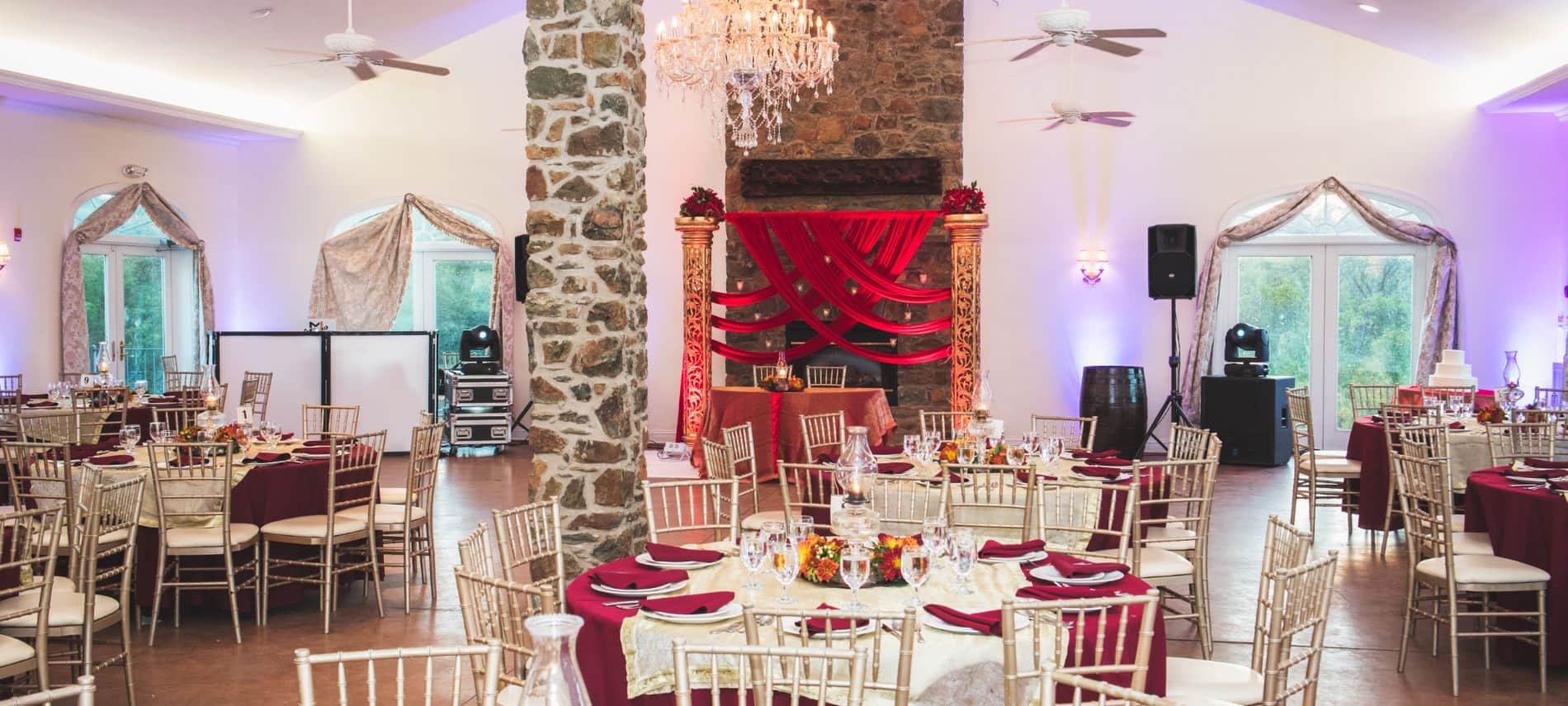 Large room decorated for a wedding reception with red tablecloths and napkins