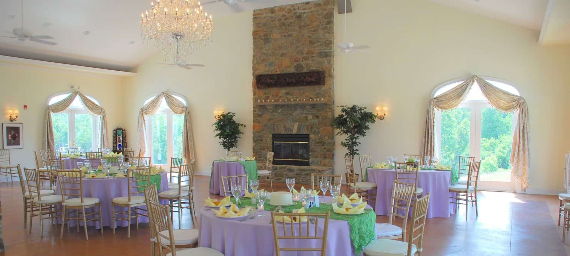 Large room decorated for a wedding reception with lavendar tablecloths and yellow napkins