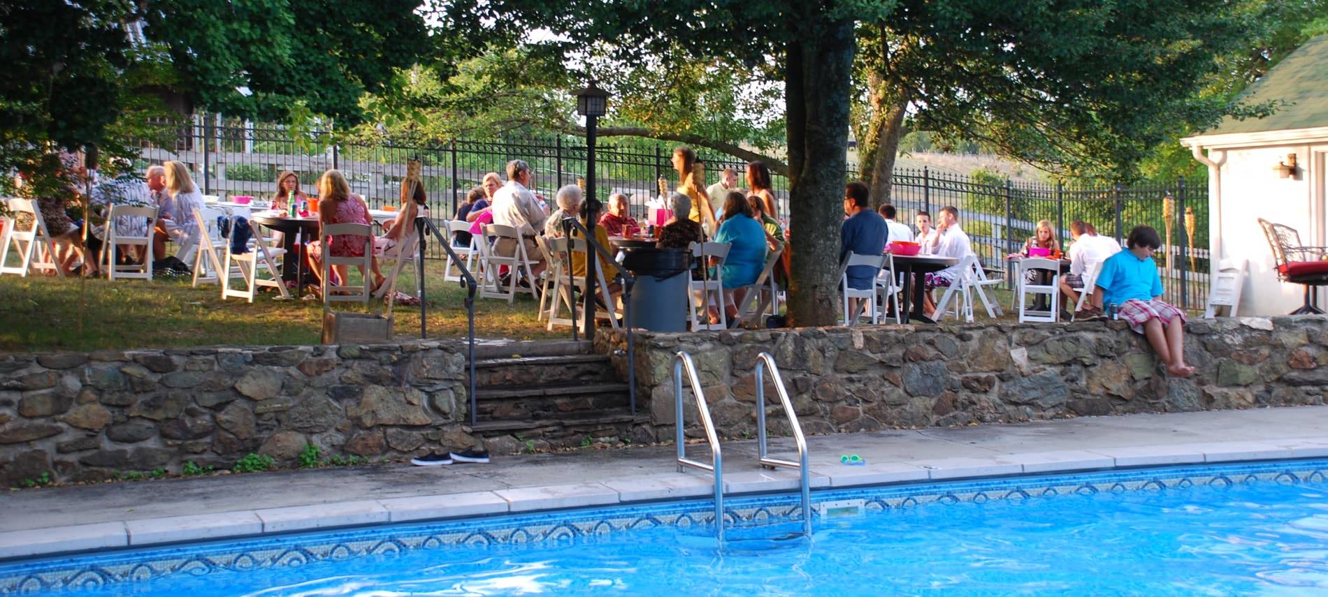 Reception tables filled with guests set up near the pool