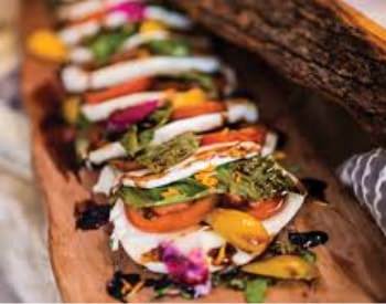 Small flour tortillas filled with grilled vegetables on a wooden plank