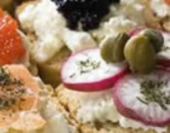 Close up view of radishes, olives, caviar, and cheese on bread